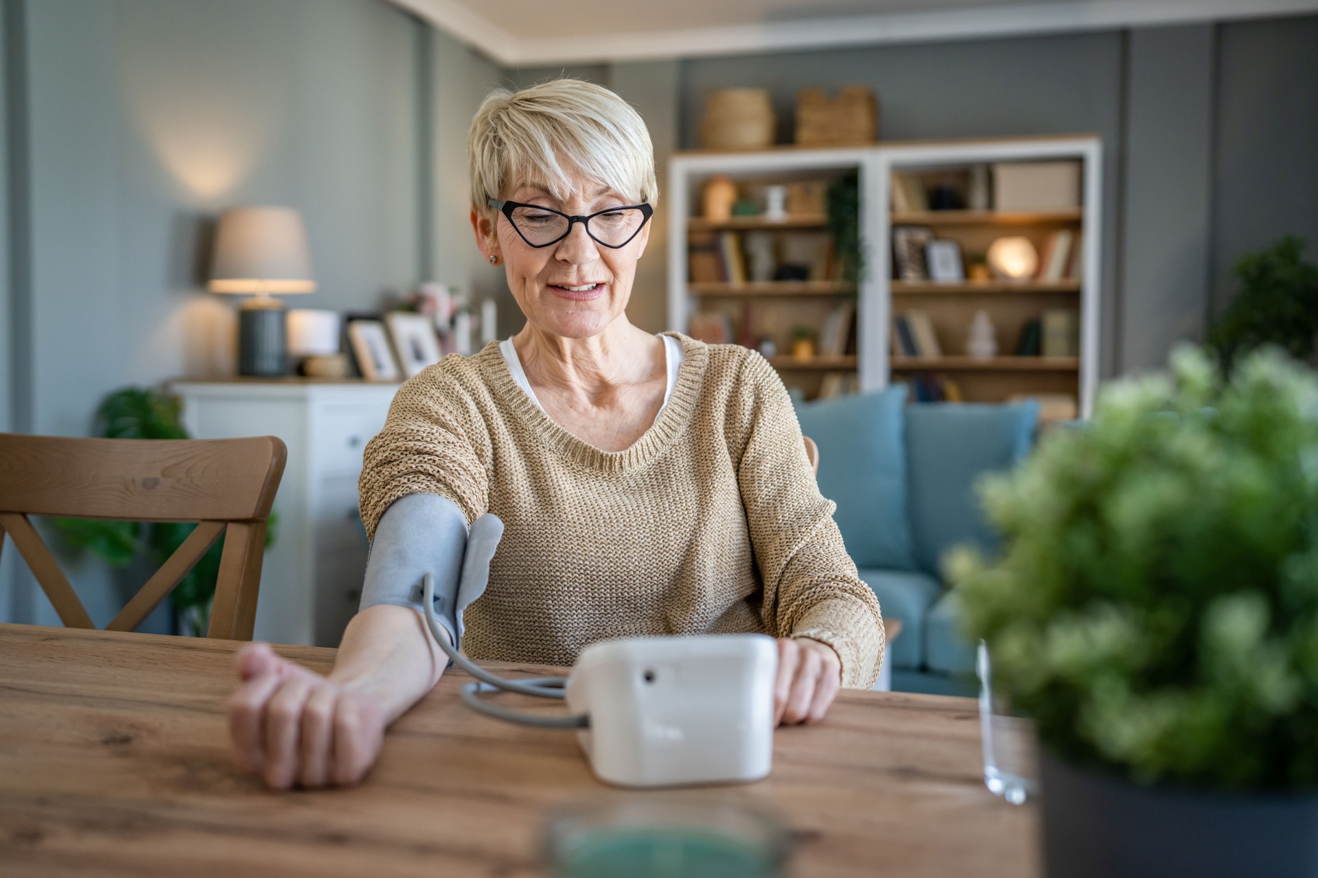 Senior caucasian woman check blood pressure measure device on hand